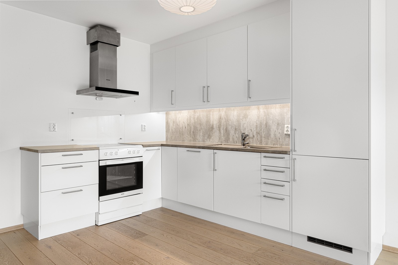 Klassisk og elegant kjøkkeninnredning med hvite slette fronter og benkeplate av laminat. Galleribilde