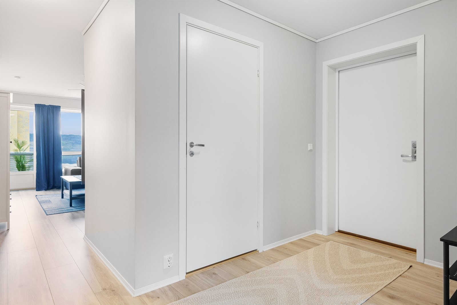 Lys og innbydende entré med enstavs gulv og lyse veggflater - et godt førsteinntrykk av leiligheten. Galleribilde