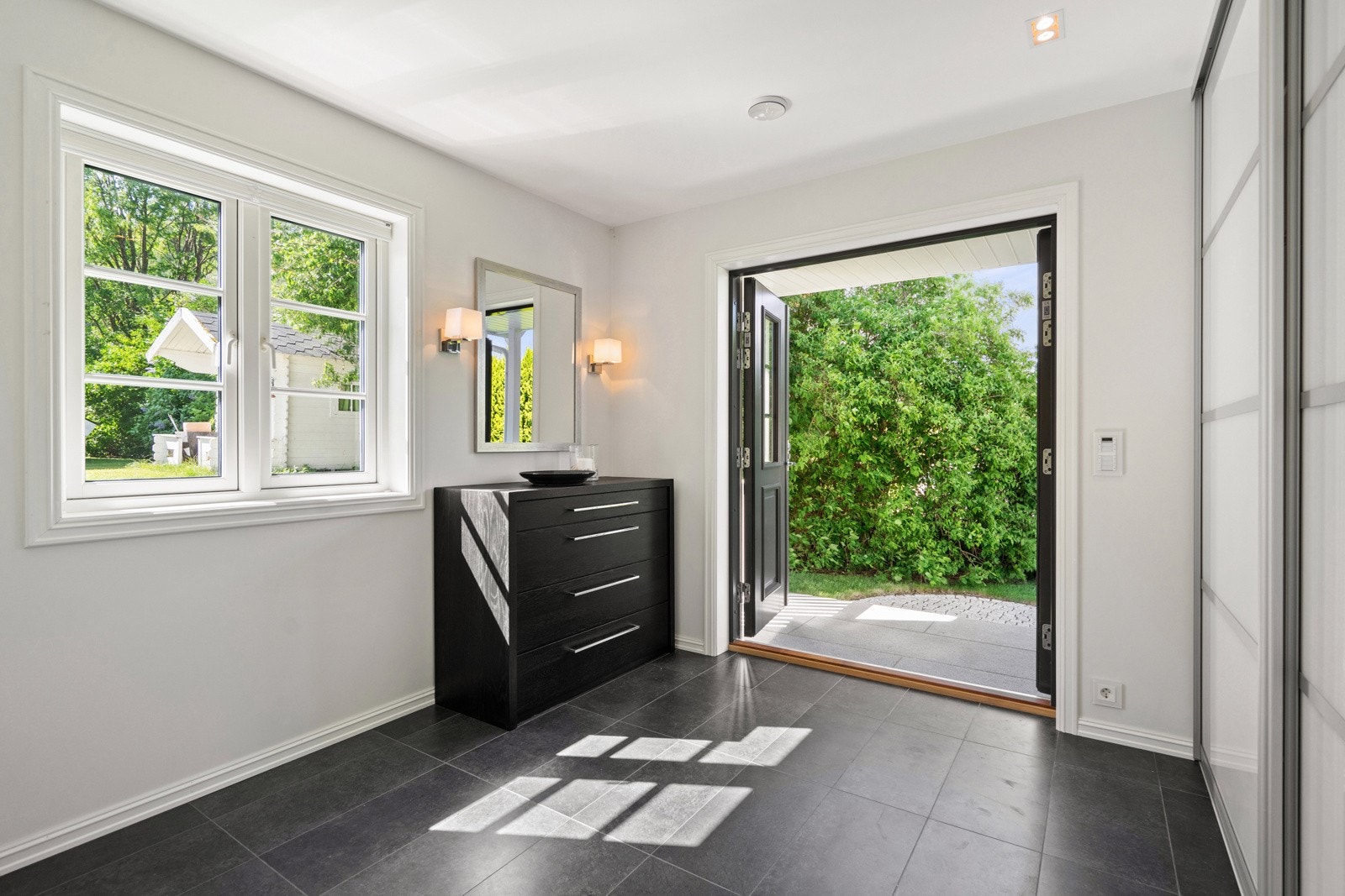 Romslig, lys og praktisk entré/gang med skyvedørsgarderobe Galleribilde