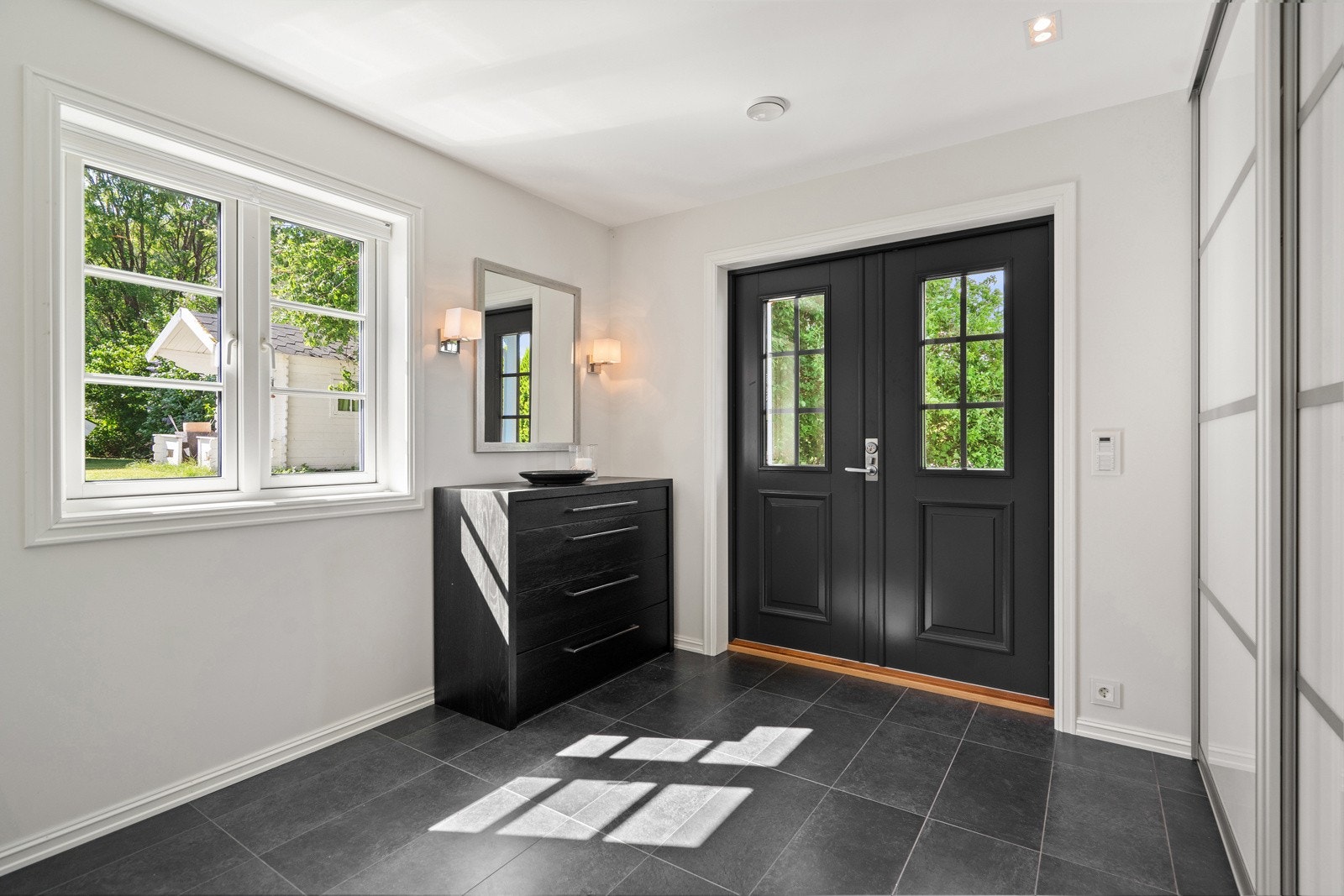 Romslig, lys og praktisk entré/gang med skyvedørsgarderobe Galleribilde