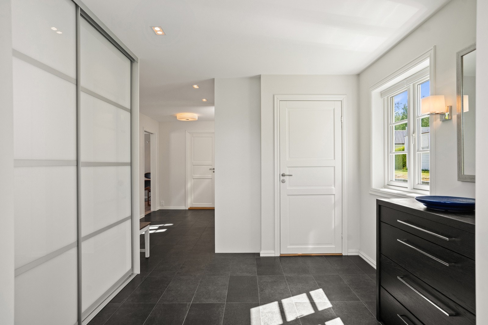 Romslig, lys og praktisk entré/gang med skyvedørsgarderobe Galleribilde