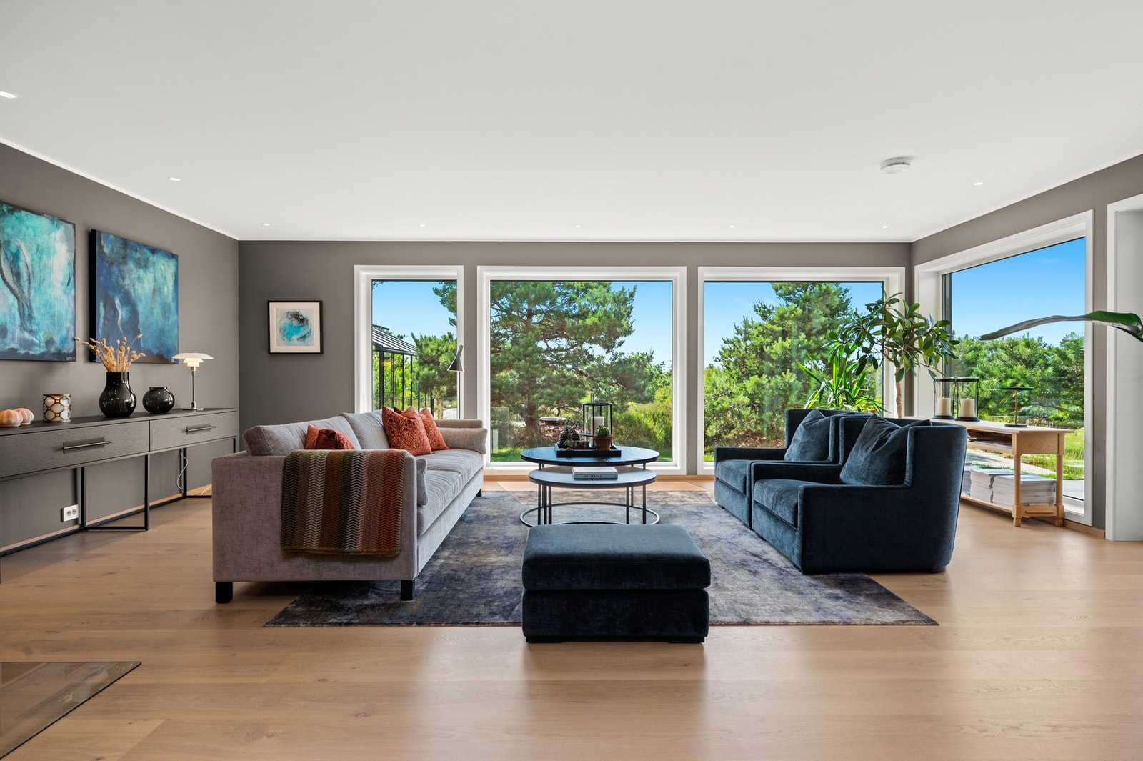 Store vindusflater i stuen som slipper inn rikelig med lys og natur Galleribilde