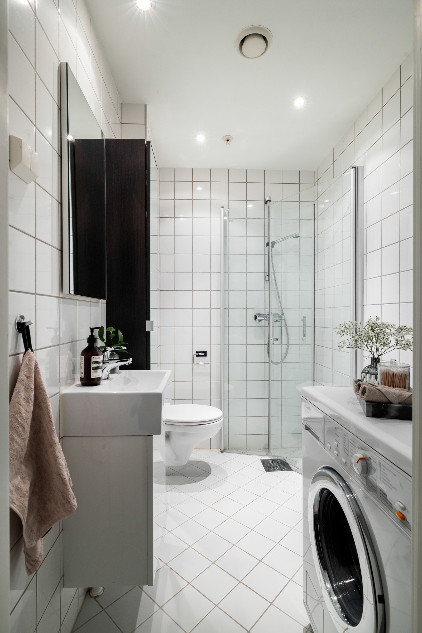 Innredningen består av servant over skapseksjon, speil, høyskap og vegghengt toalett. Videre har badet dusjhjørne med innfellbare glassdører. Badet har også opplegg for vaskemaskin Galleribilde