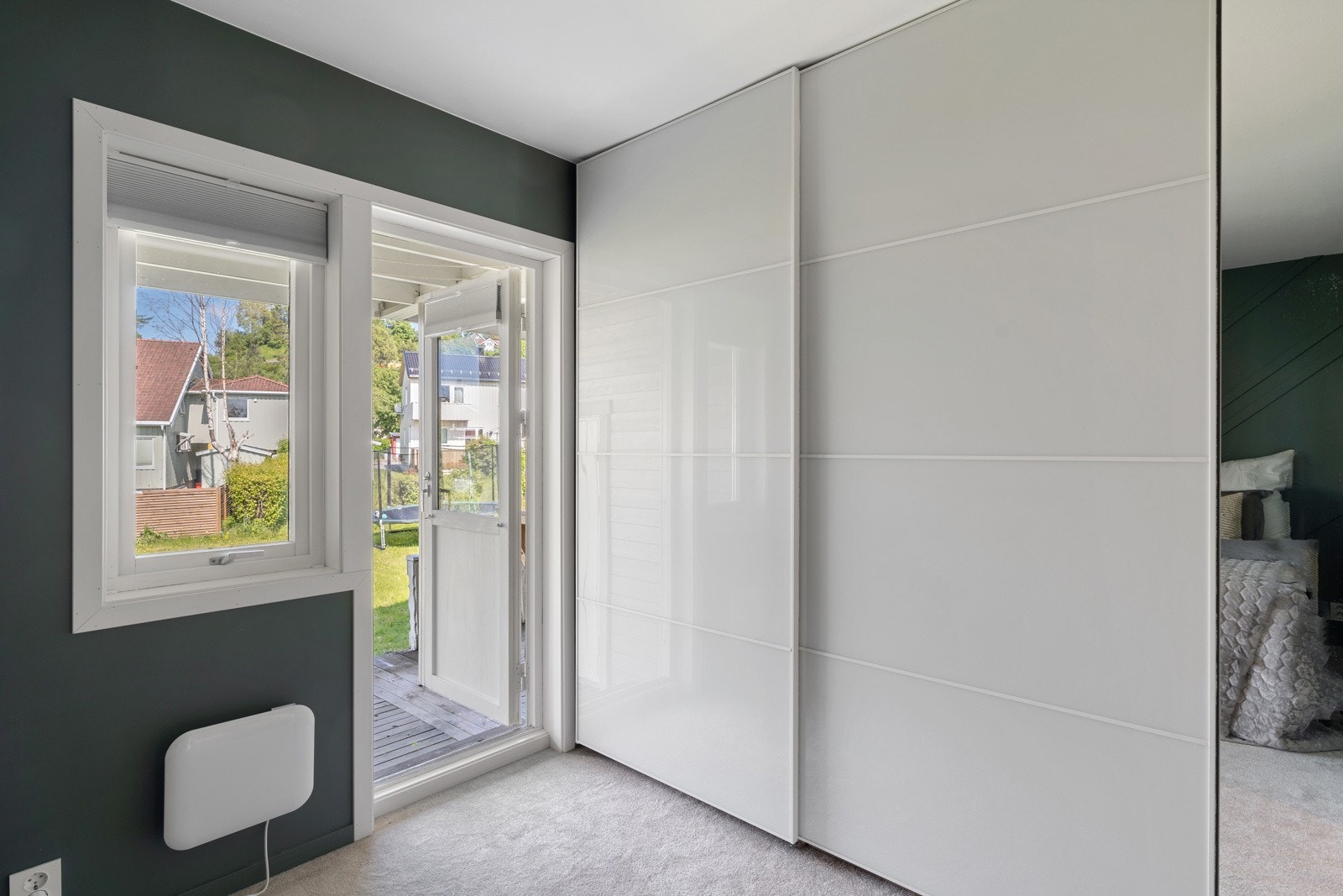 Soverommet har en romslig skyvedørsgarderobe med speilfront og utgang til platting og hage. Galleribilde
