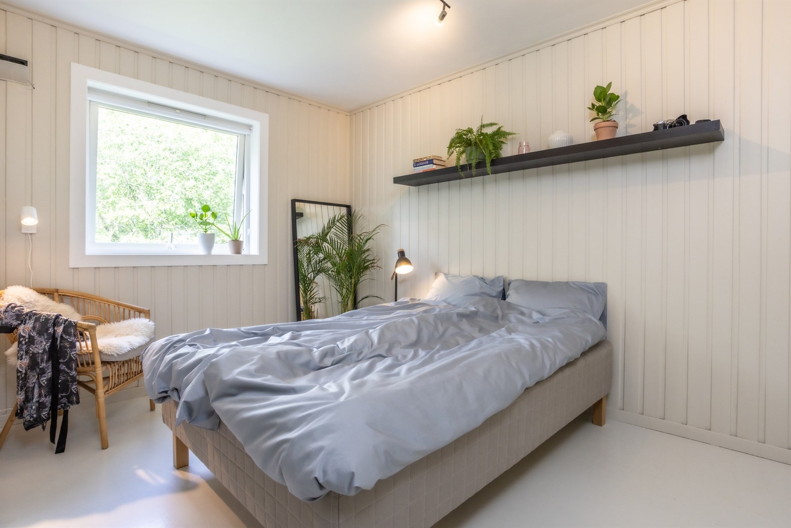 Et behagelig soverom med grønne løvtrær utenfor. Galleribilde