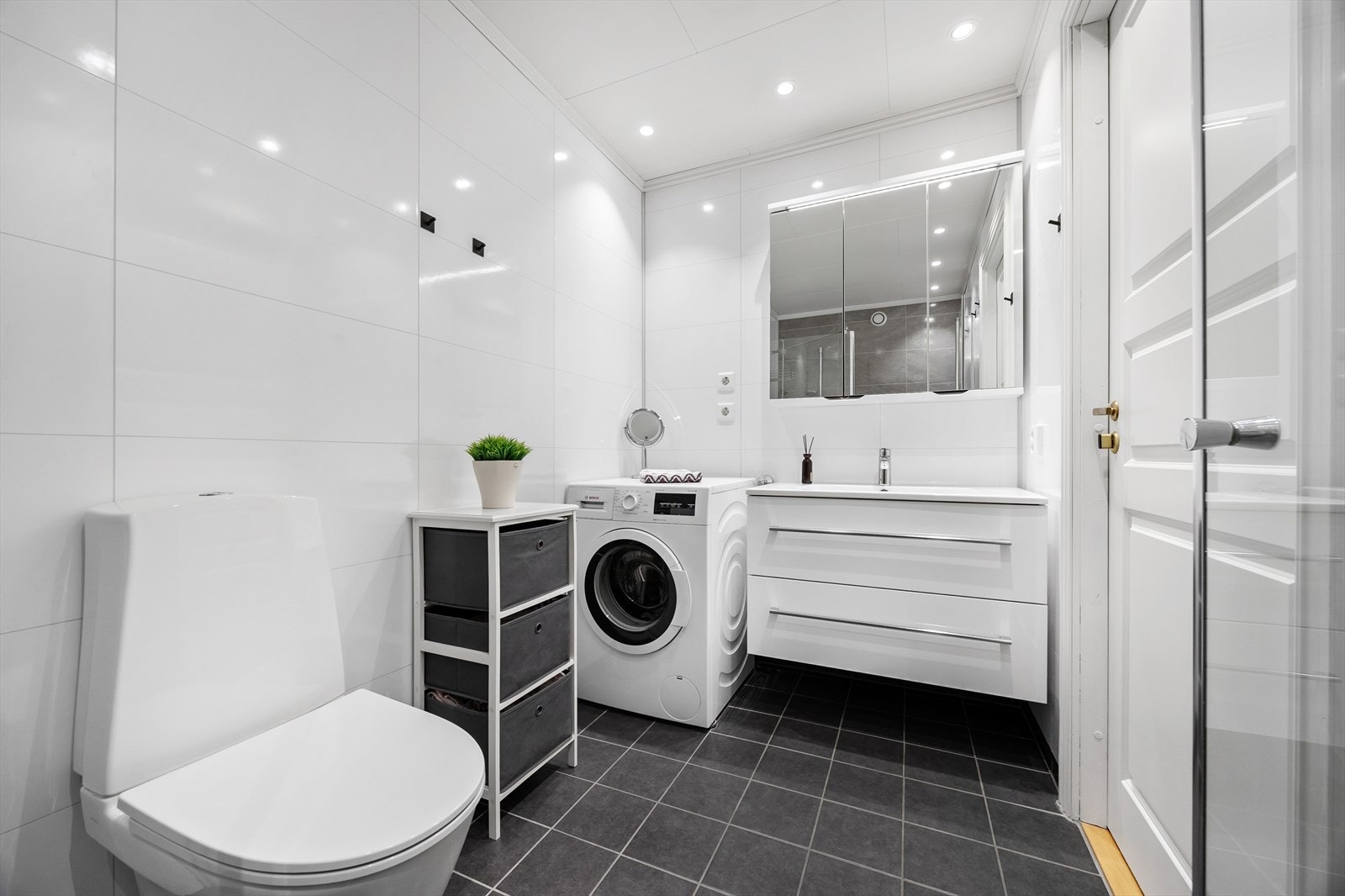 Badet har moderne innredning, vegghengt toalett og stor servant med speil. Galleribilde