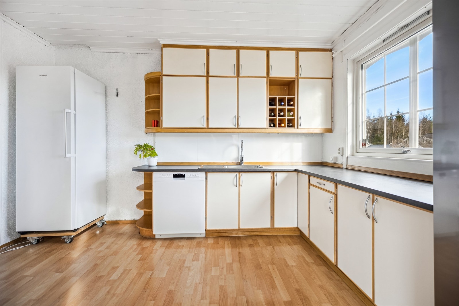 Belysning under overskap og mosaikkfliser på vegg over benkeskap ved komfyr. Galleribilde