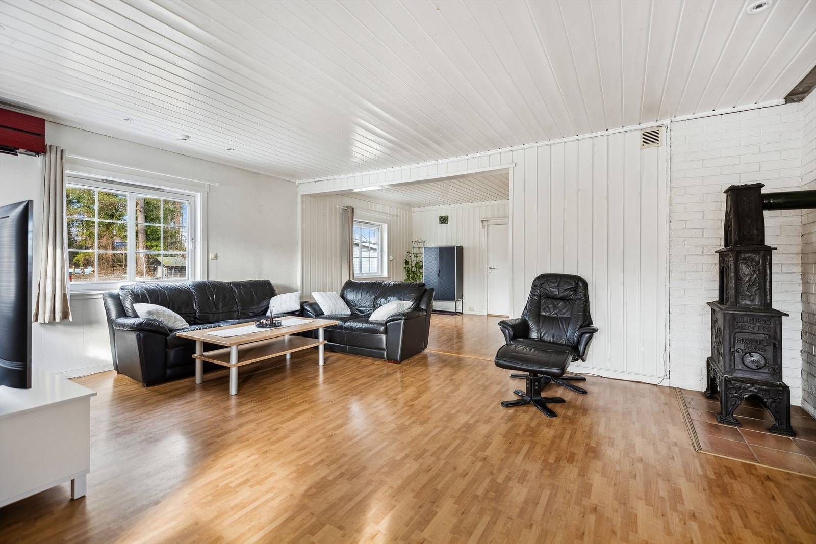 Lys og trivelig stue med flere muligheter for møblering samt en hyggelig peisovn. Galleribilde