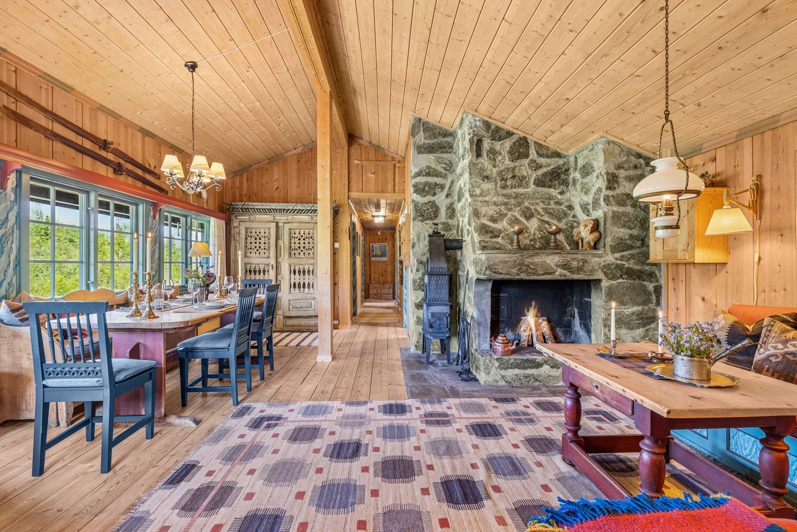 Stue og spisestue utgjør et herlig samlingspunkt i hytta - et rom som virkelig innbyr til både avslapning og hyggelige måltider. Her er det god plass til gjennomført innredning, og den moderne peisovnen sørger for lun varme på kjølige dager. Galleribilde