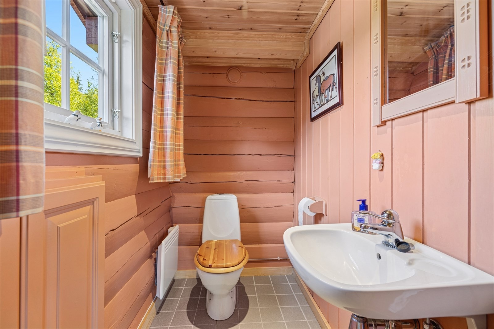 Toalettrommet i nyere del har flislagt gulv, samt malt panel og tømmervegger - og fremstår som et stilrent og praktisk tillegg. Galleribilde