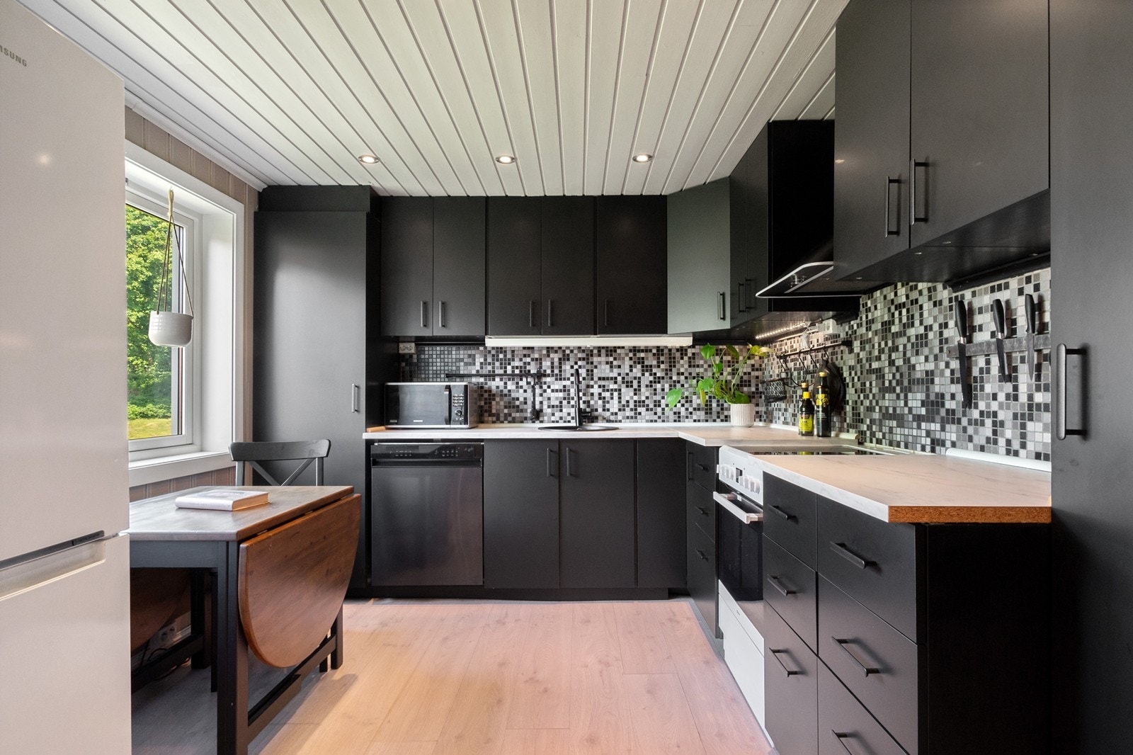 Leiligheten har et moderne Ikea kjøkken fra 2024, med god oppbevaring i over- og underskap. Innredningen er moderne med slette, mørke fronter og laminat benkeplate. Galleribilde