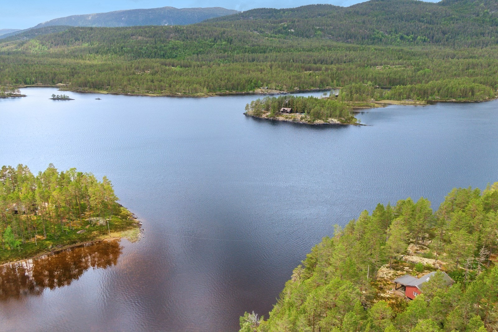 Hytta ligger på ett høydedrag med usjenert beliggenhet i skogsterreng og utsikt mot Holmevatn. Galleribilde