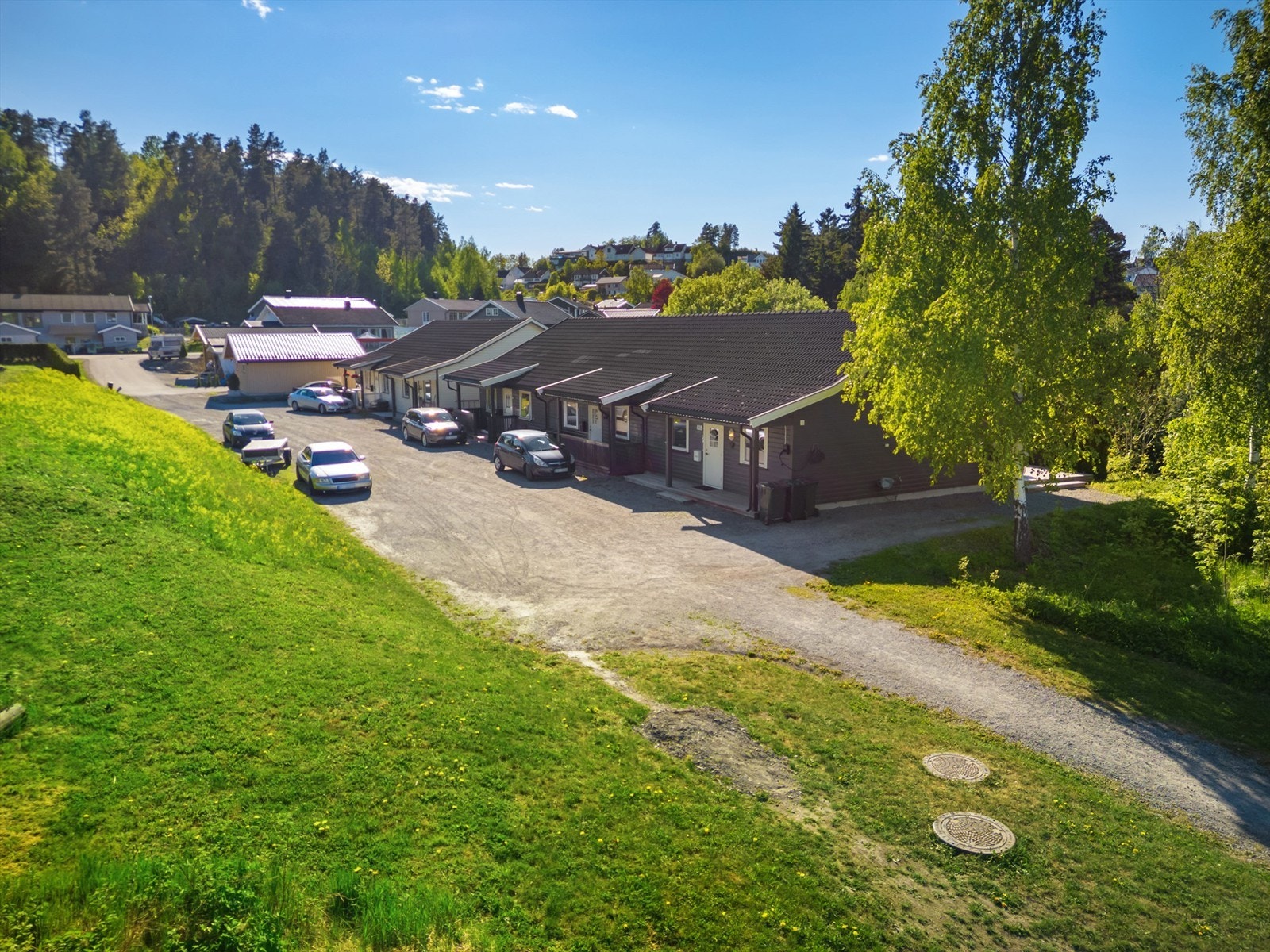 Parkering på gruset gårdsplass som tilhører sameiet Galleribilde