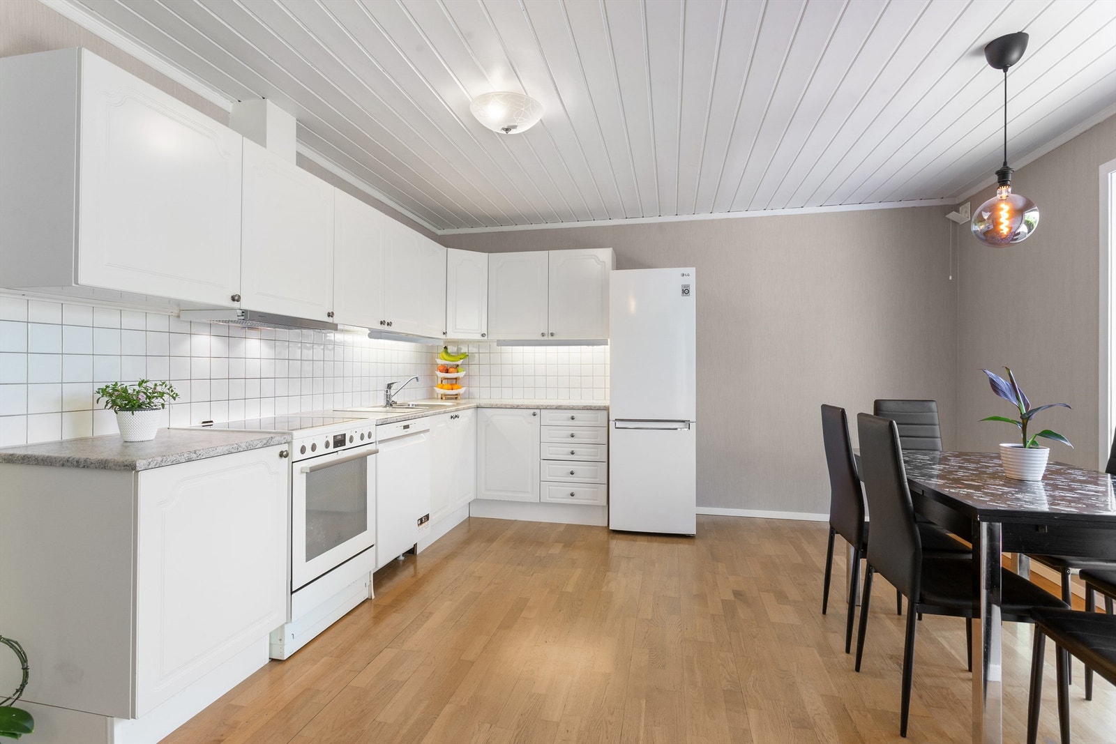 Fliser mellom kjøkkenbenk og overskap. Benkeskapsbelysning og stikkontakter over kjøkkenbenk Galleribilde