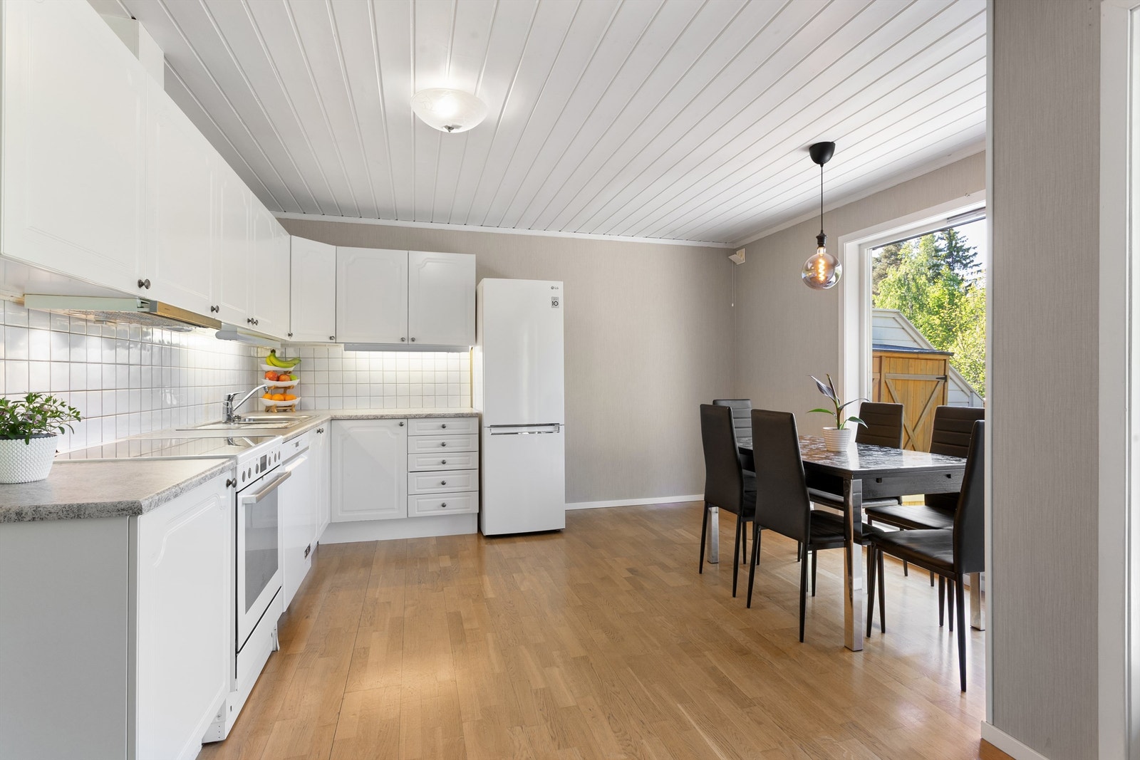 Ende rekkehus - Kjøkken med mye lys fra store vinduer ut mot terrasseplattingen og god plass for spisestue Galleribilde