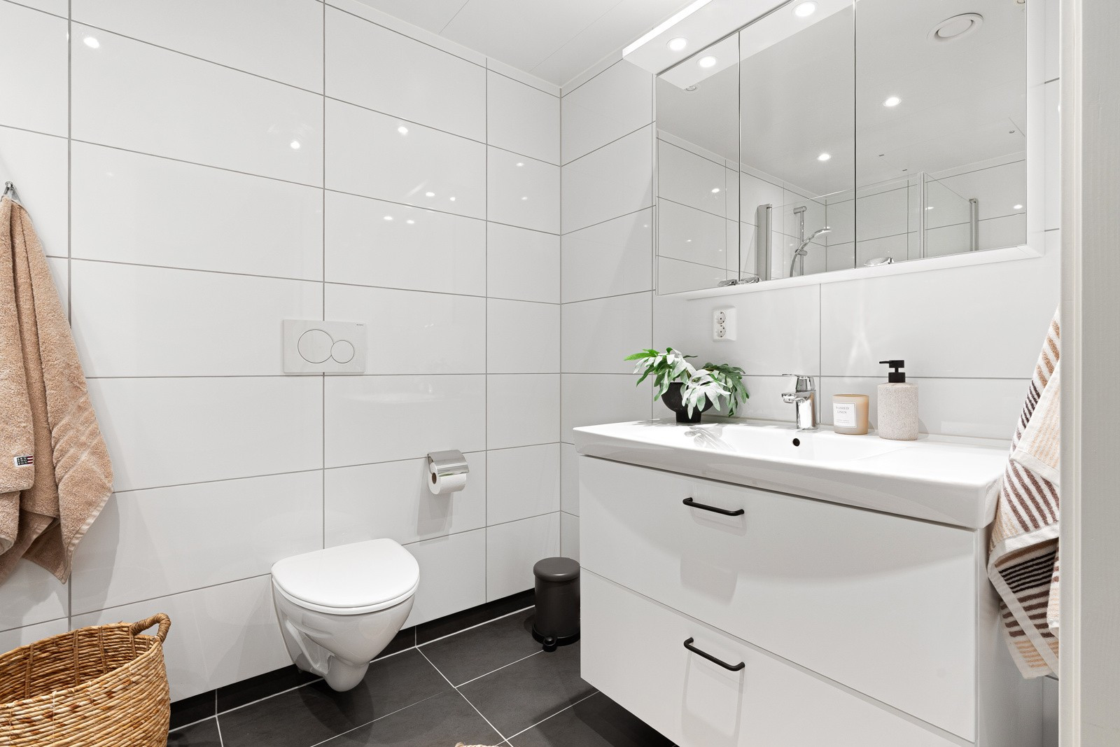 Lekker bad/vaskerom med gulvvarme, lekre fliser og downlights i himling. Lys baderomsinnredning og speilskap.