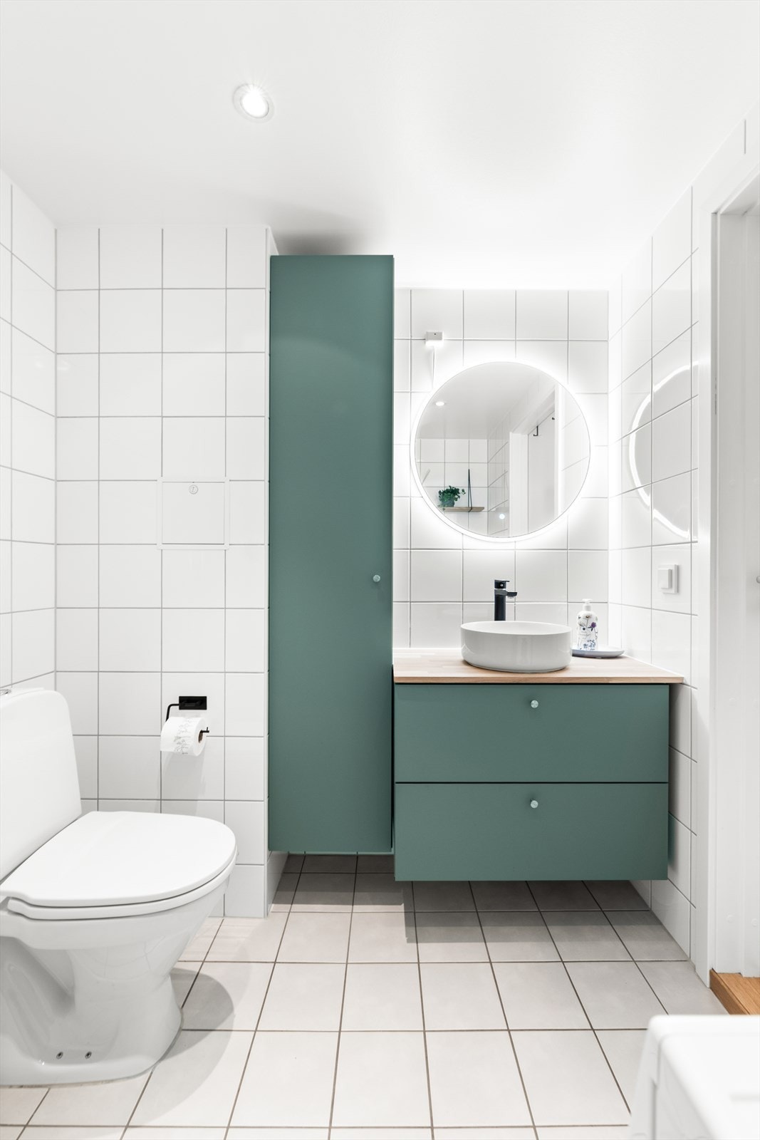 Badet har flislagte vegger og en malt, slett himling med innfelte downlights som gir godt og behagelig lys. Galleribilde