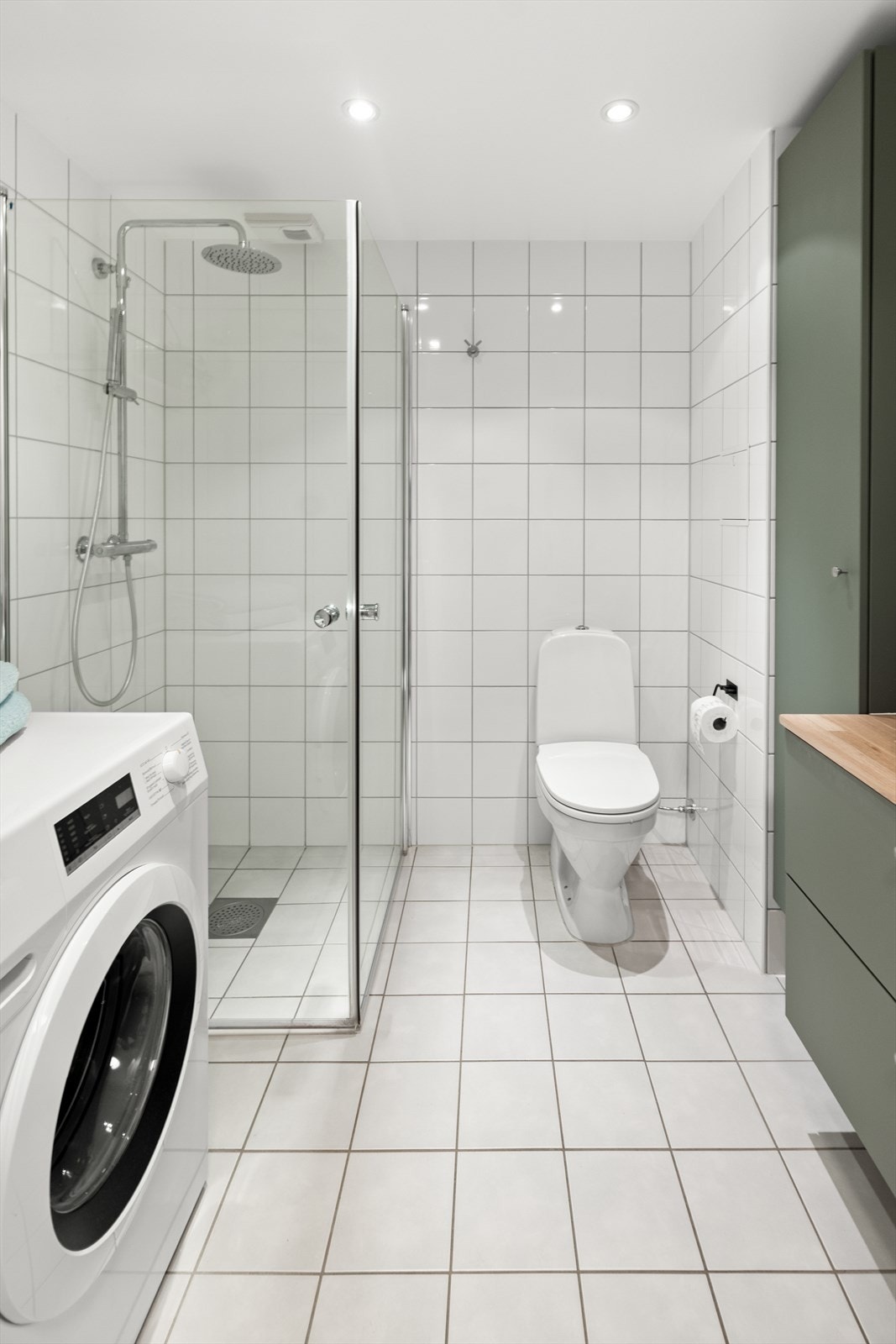 Badet har flislagte vegger og en malt, slett himling med innfelte downlights som gir godt og behagelig lys. Galleribilde