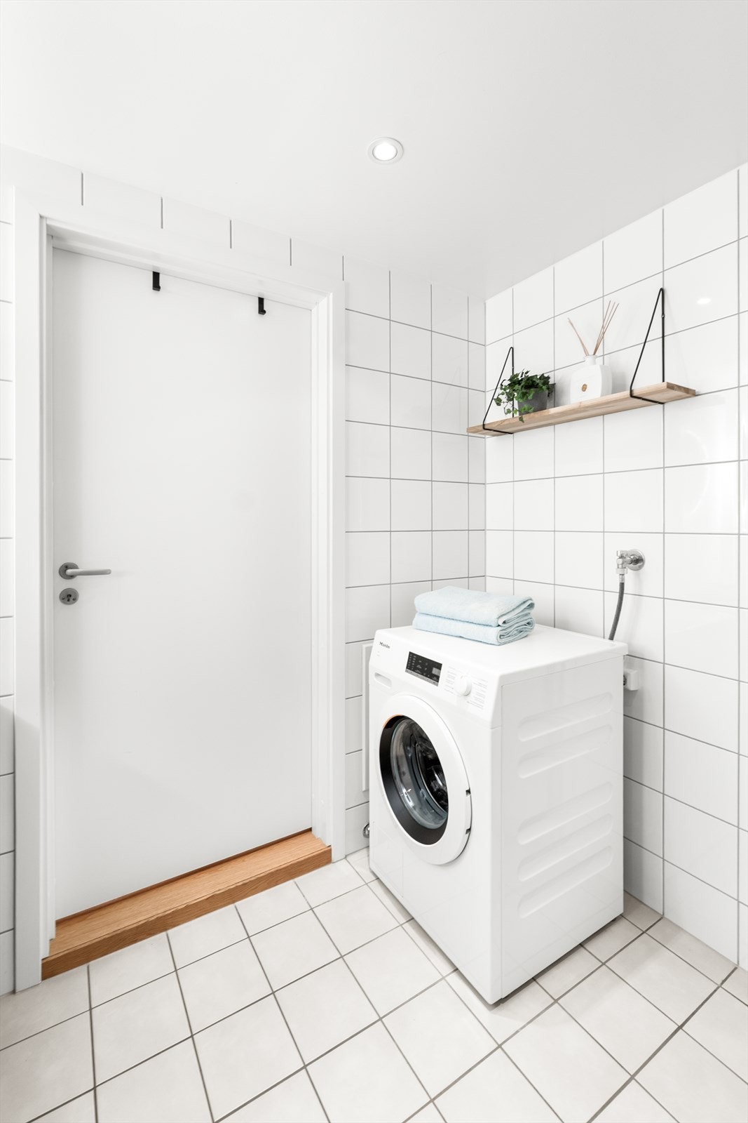Badet har flislagte vegger og en malt, slett himling med innfelte downlights som gir godt og behagelig lys. Galleribilde