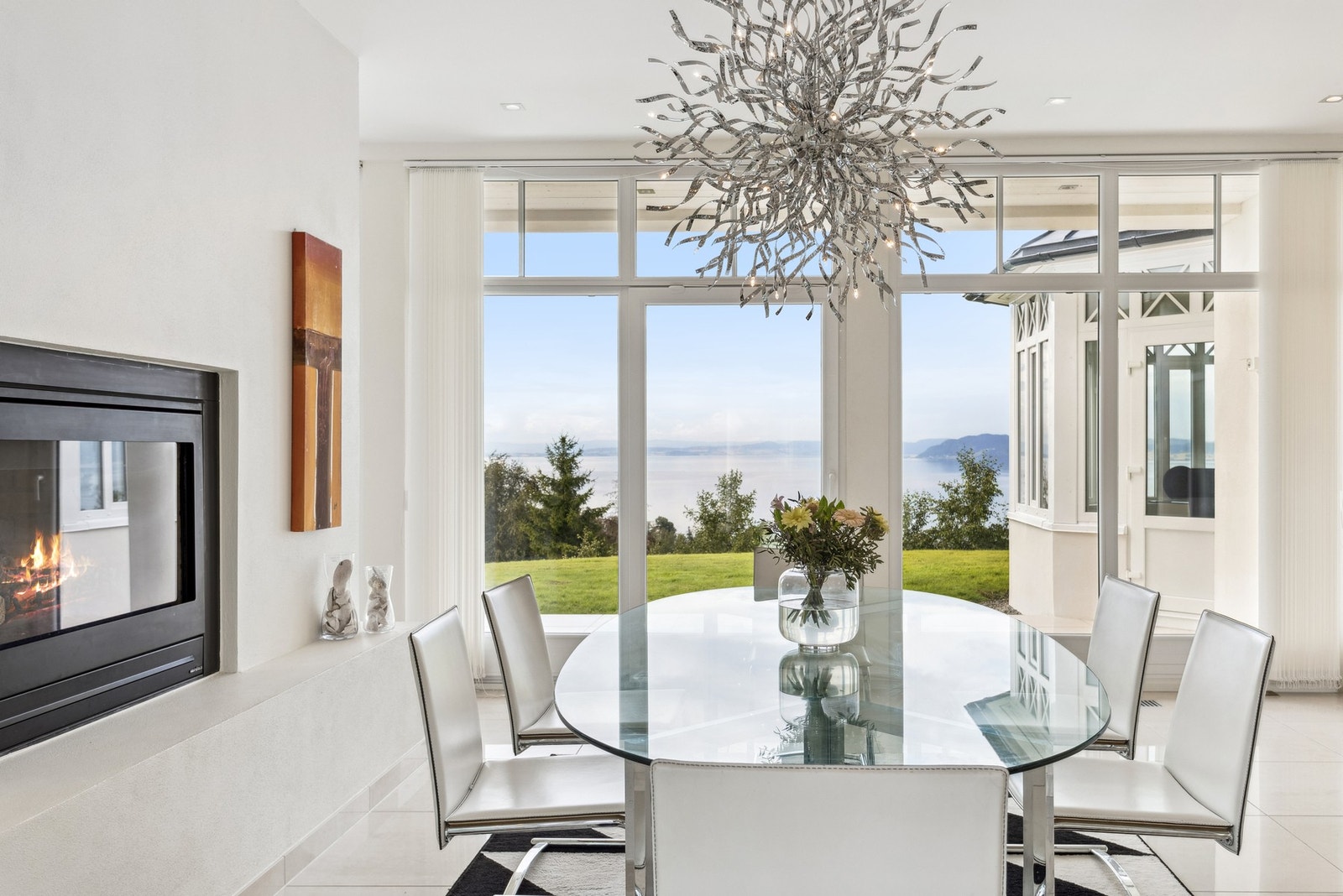 Mellom kjøkken og spisestue er det en lekker gasspeis som deler rommet på elegant vis og gir en lun atmosfære til begge soner. Galleribilde