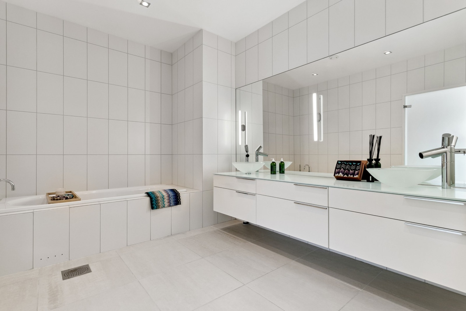 Badet i sidefløyen med fire soverom har innfliset badekar og familievennlig innredning med dobbel servant og god skapplass. Galleribilde