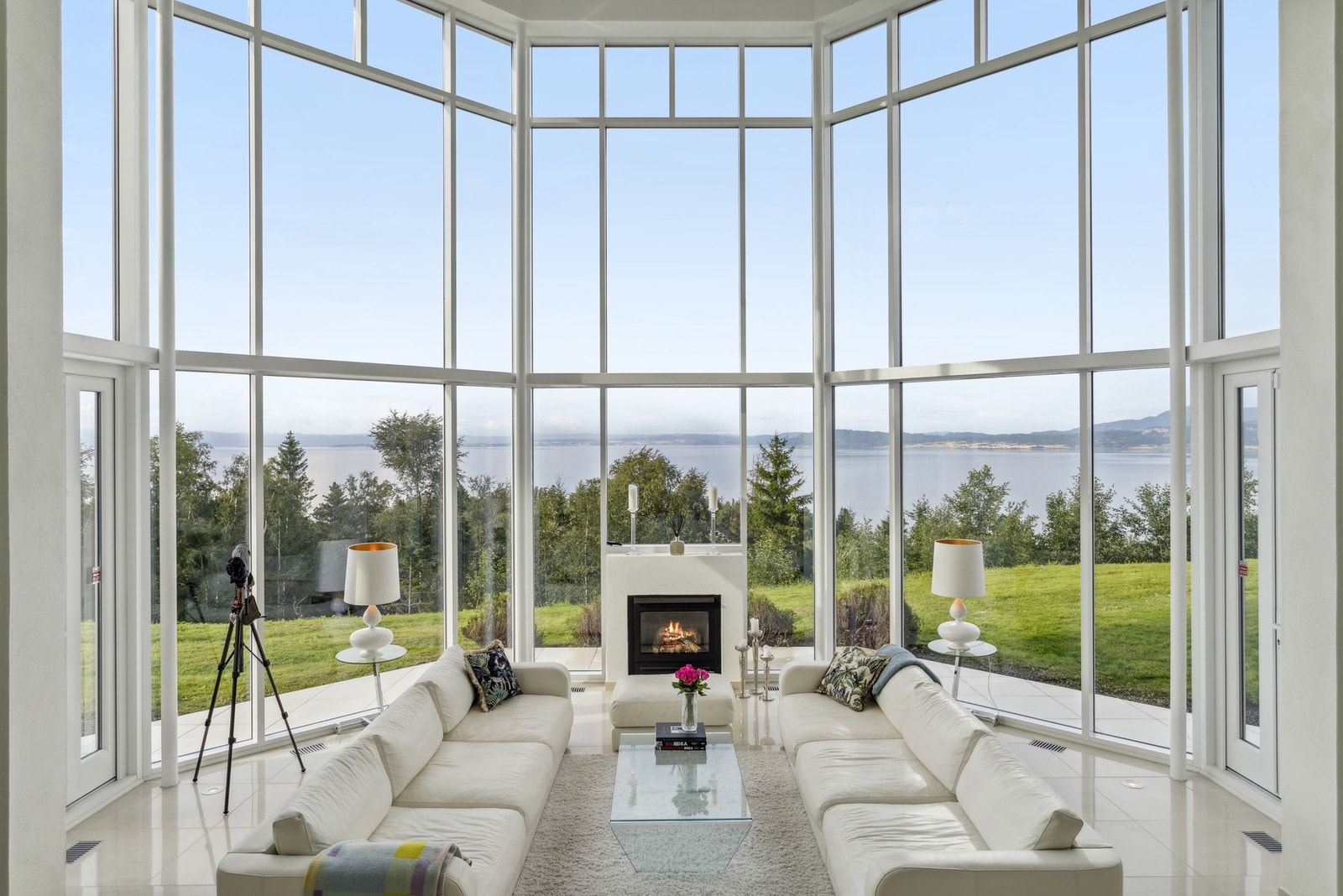 Den midtstilte stuen har glassfasade over to etasjer og spektakulær utsikt der fjorden føles som en del av interiøret. Galleribilde