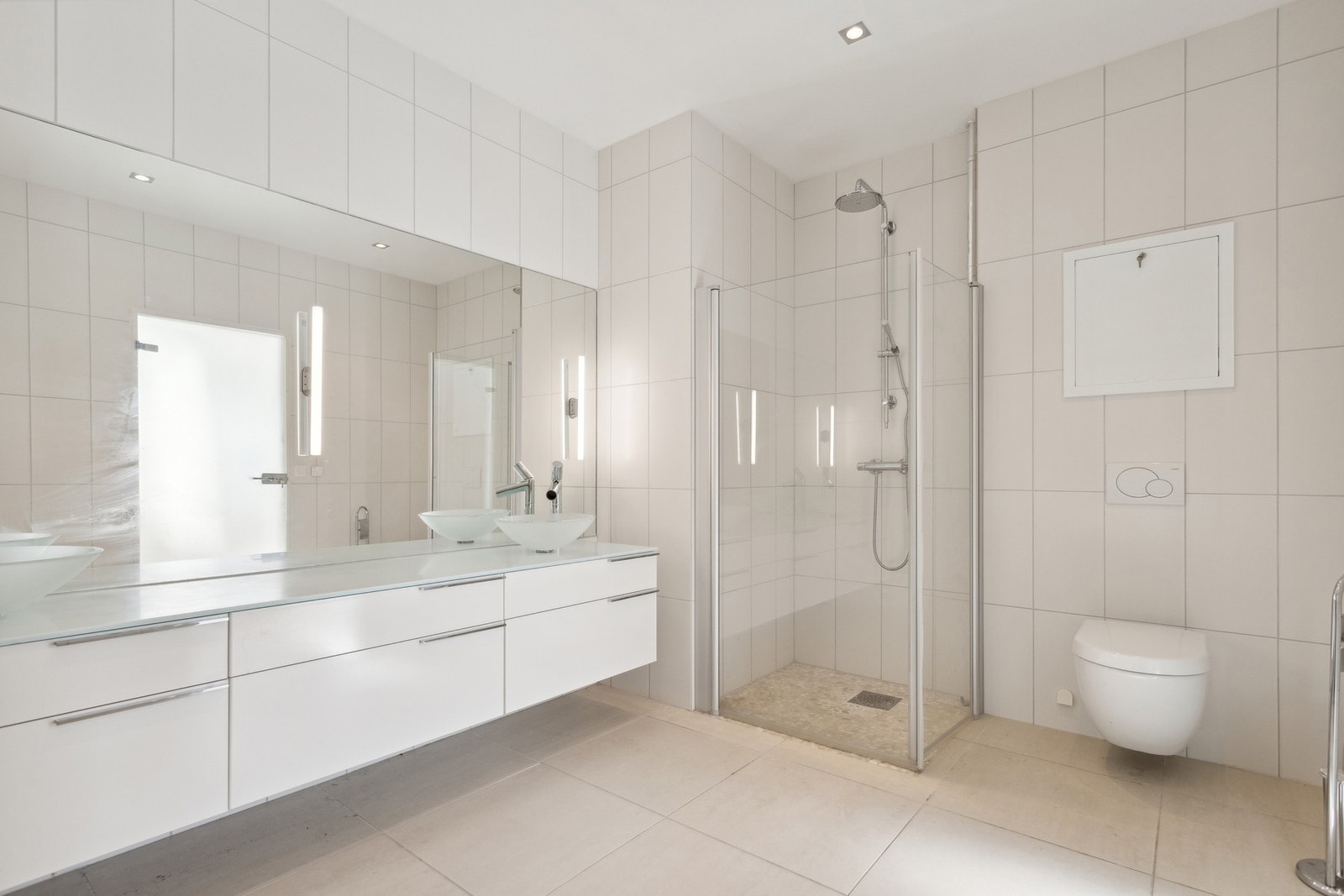 Delikat med dusjnisje, vegghengt toalett og innredning i tidsriktige, nøytrale fargetoner. Galleribilde