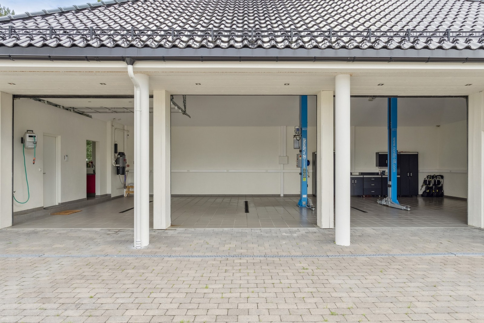 Trippelgarasjen har god takhøyde, direkte tilkomst fra gårdsplass og rikelig med plass til kjøretøy, oppbevaring og utstyr. Galleribilde