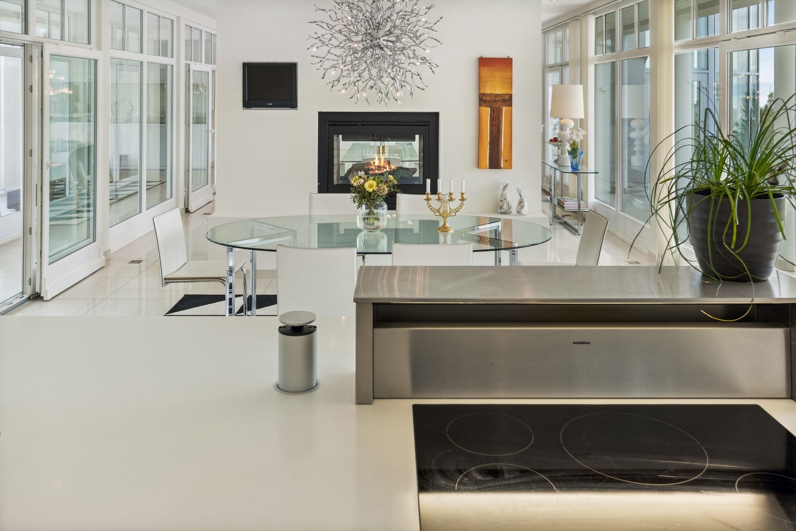 Den elegante kjøkkenøya har benkeplate i lys komposittstein, og er utstyrt med planlimt induksjonstopp, benkeventilator og praktisk pop-up-strøm. Galleribilde