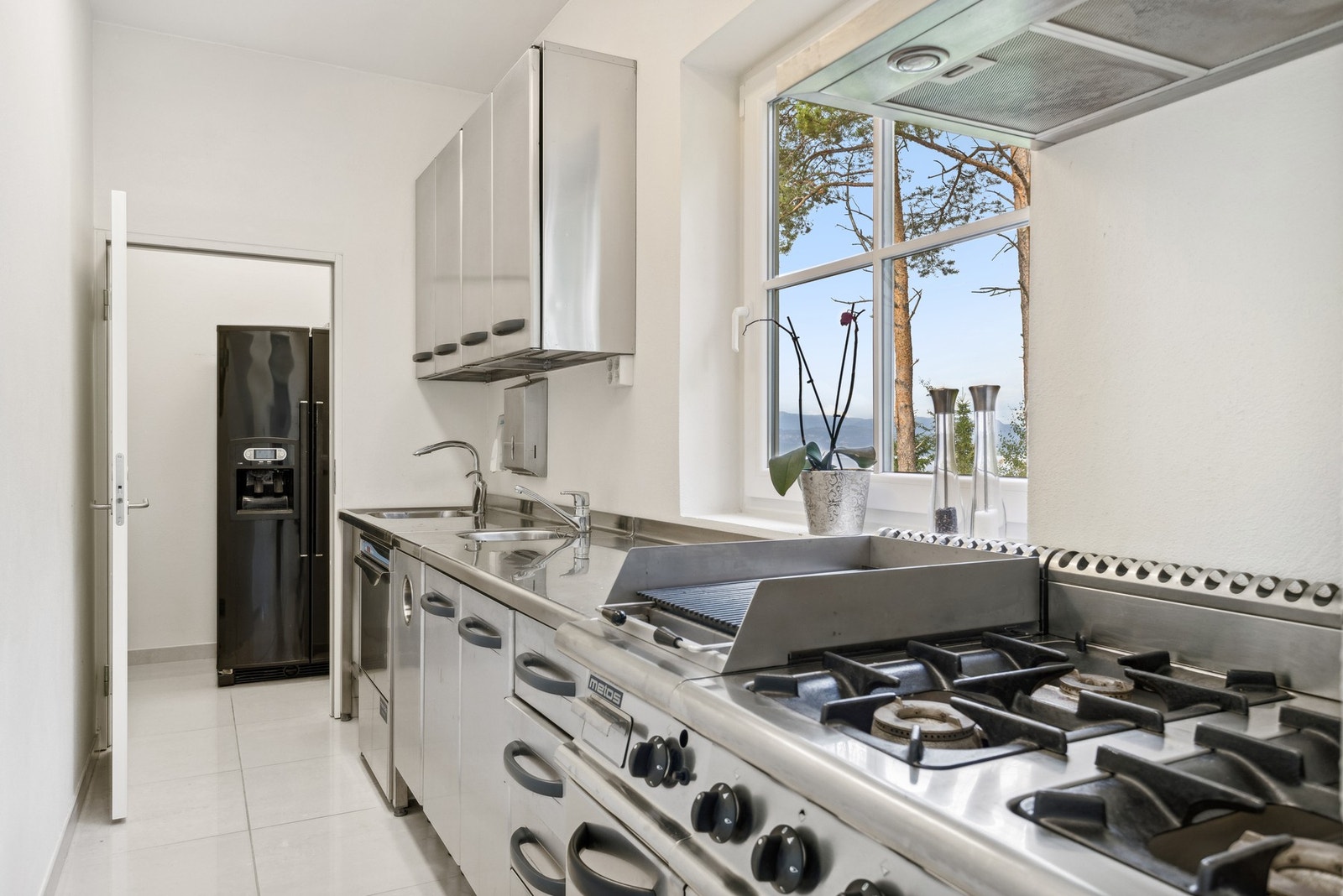 I bakkant av kjøkkenet er det et smart grovkjøkken, industrielt innredet og perfekt for anretning. Galleribilde