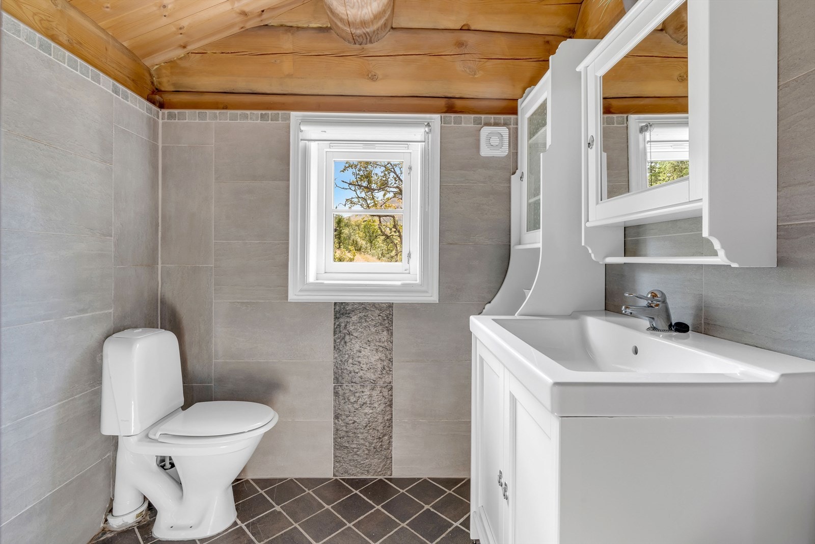 Badet i gjestehytta har flislagt gulv og vegger. Galleribilde