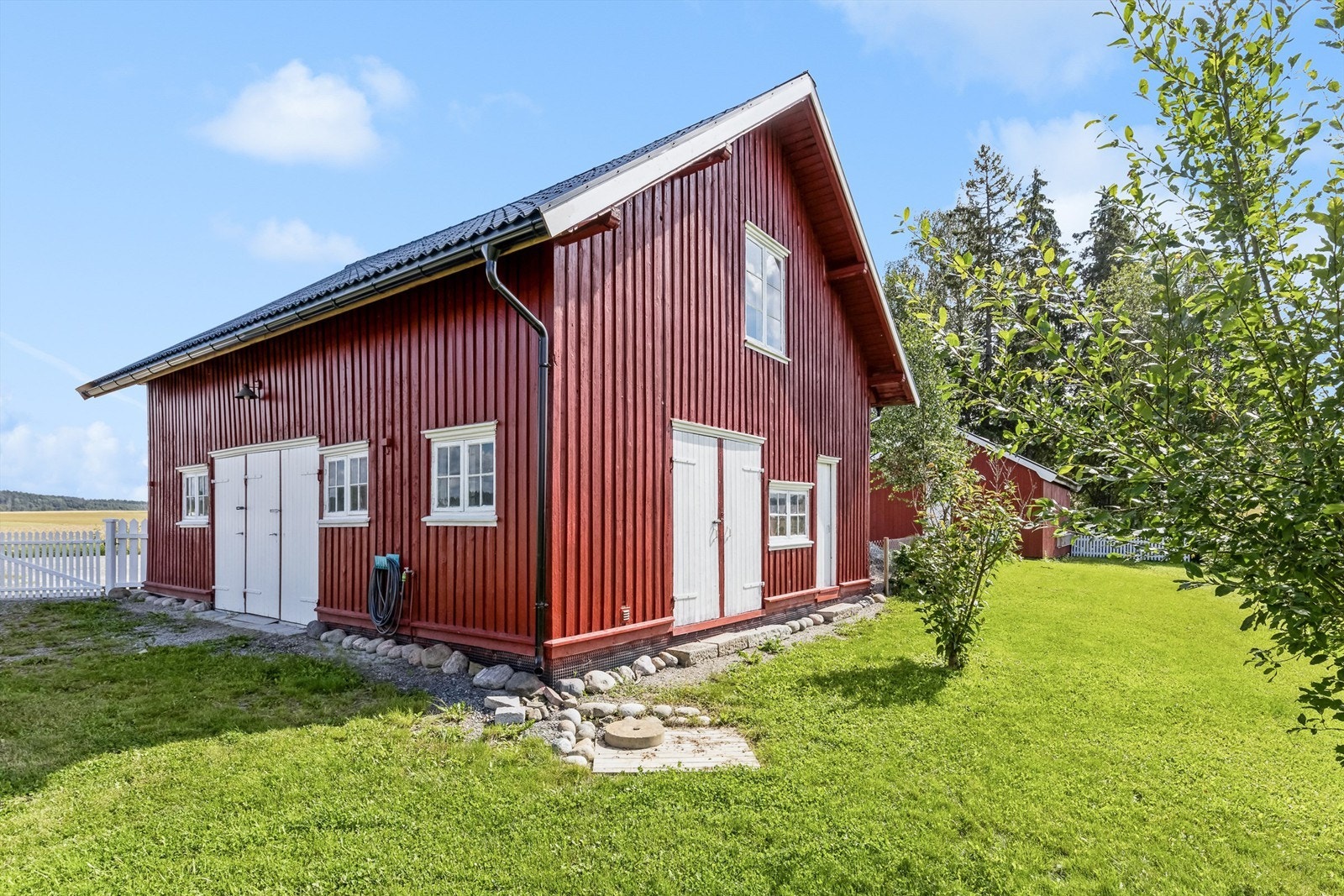 Garasjebygget går over to etasjer og rommer garasjeplass, samt hobbyrom og redskapsrom. 2. etasje har lagringsrom og innredet rom Galleribilde