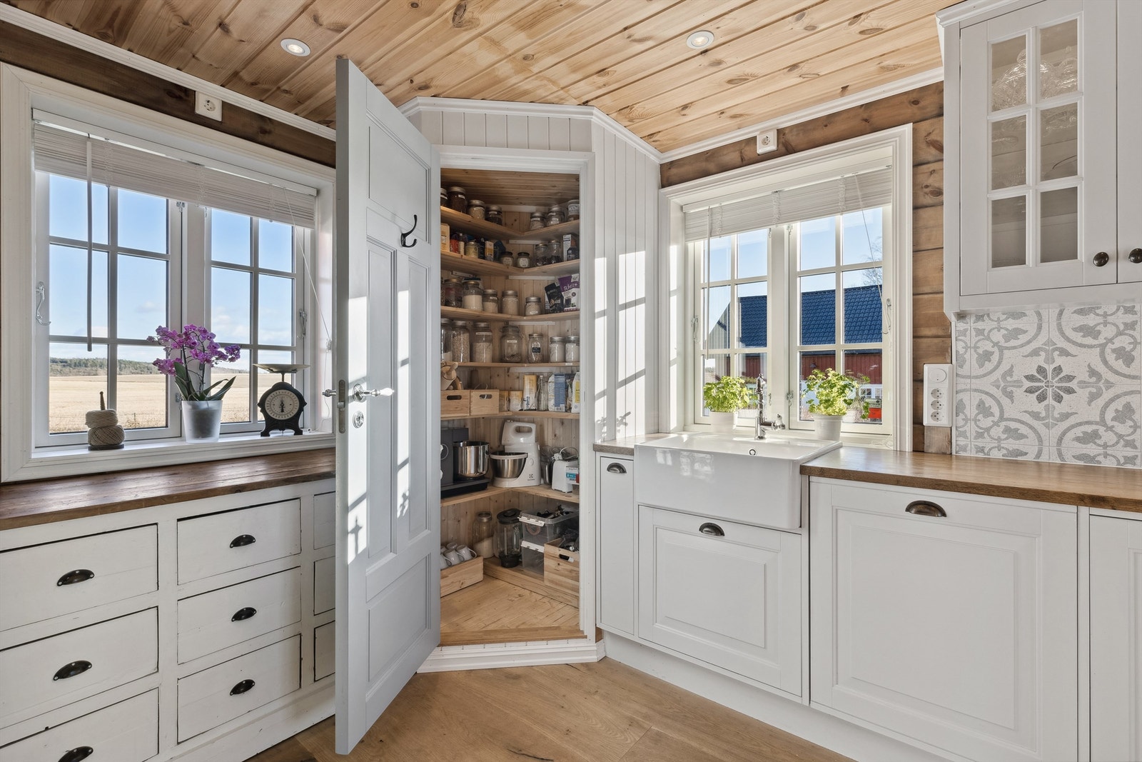 Kjøkkenet har et plassbygget matskap i hjørne Galleribilde