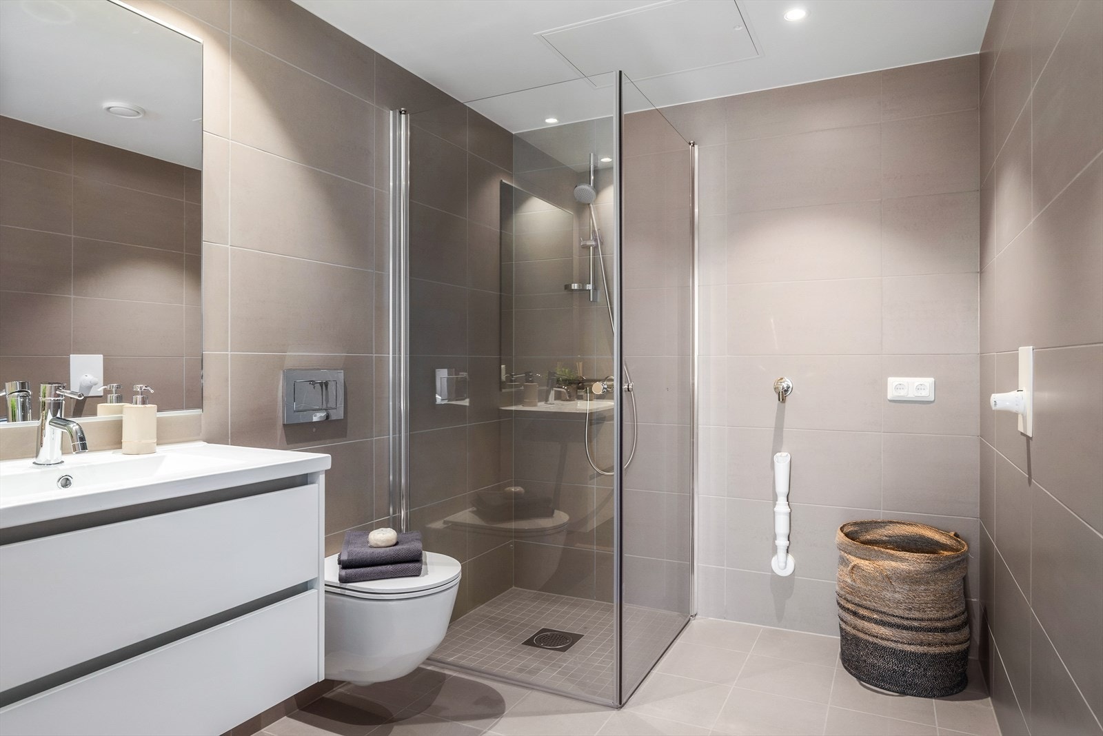 Moderne flislagt bad med opplegg for vaskemaskin Galleribilde