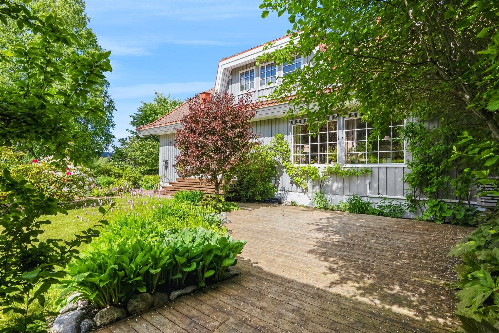 Terrasser på tilsammen 63 kvm som omkranser deler av eiendommen. Galleribilde