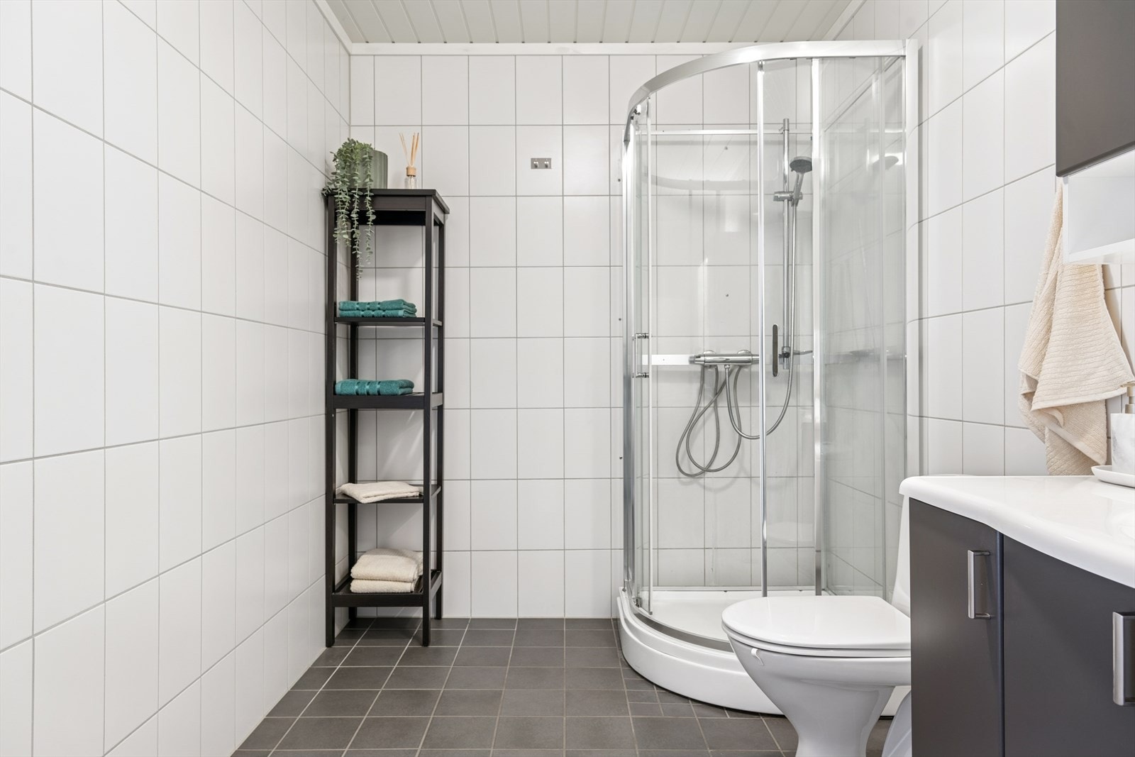 Innbyende bad med lyse vegger og flislagt gulv. Galleribilde