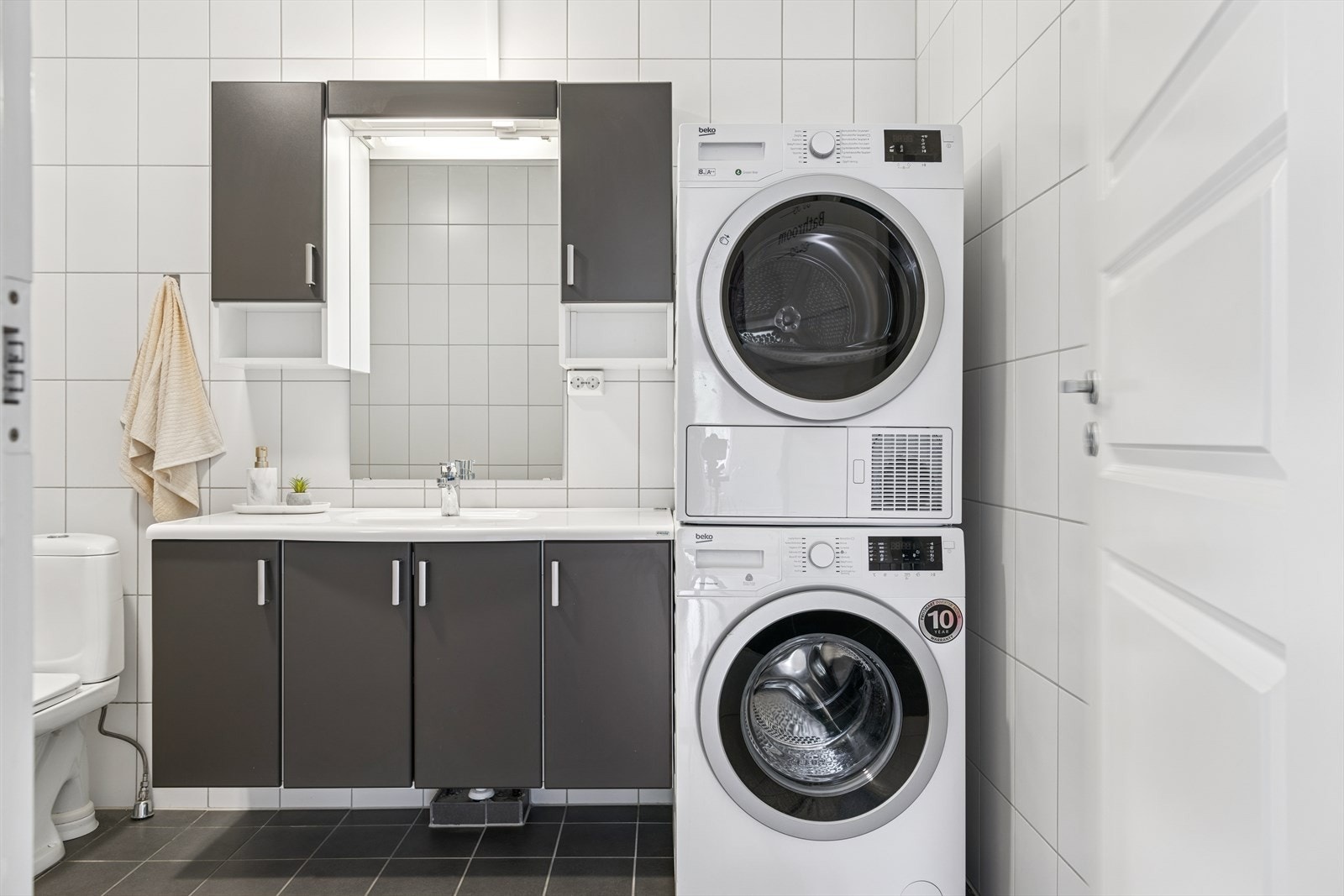 Stilren og mørk innredning. Opplegg til vaskemaskin og tørketrommel. Galleribilde