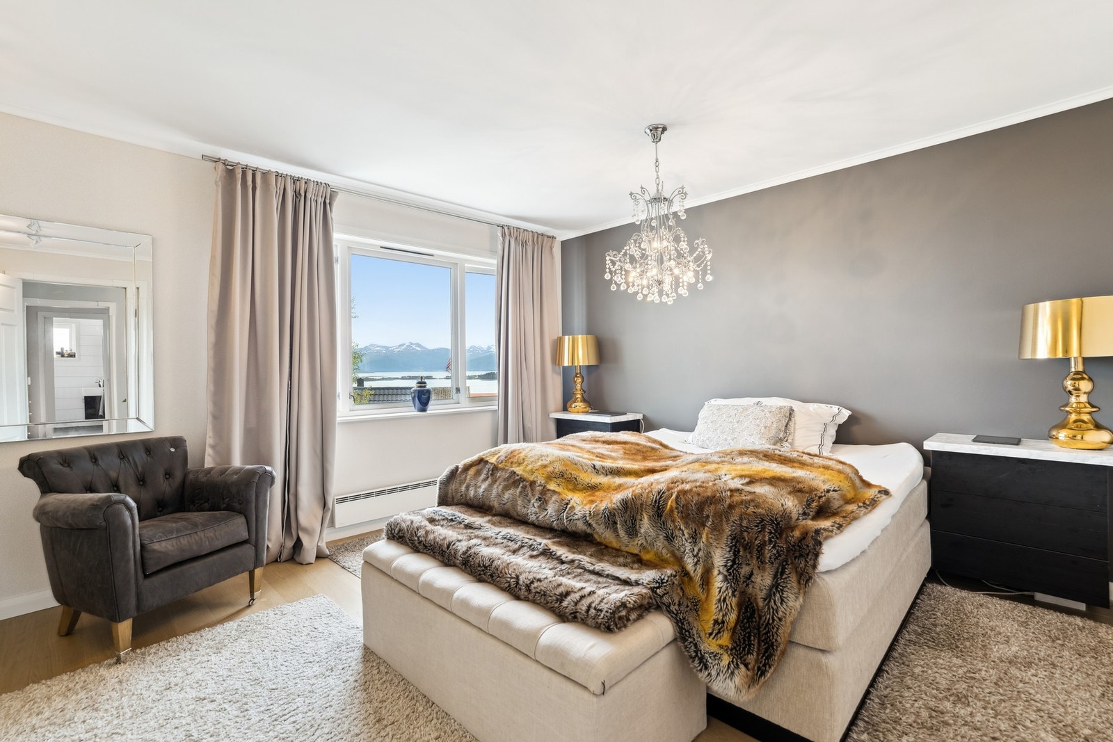 Stort hovedsoverom på boligens sørside med flott utsikt mot fjorden og Romsdalsalpene. Galleribilde