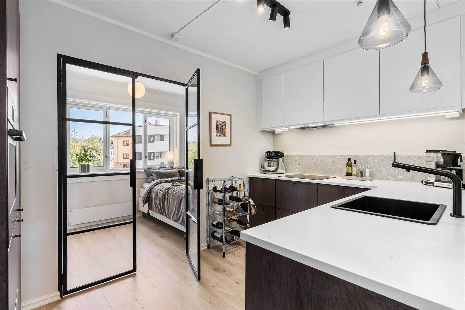 En lekker smijernsdør med glassfelter sørger for et fint lysinnslipp gjennom rommene. Galleribilde