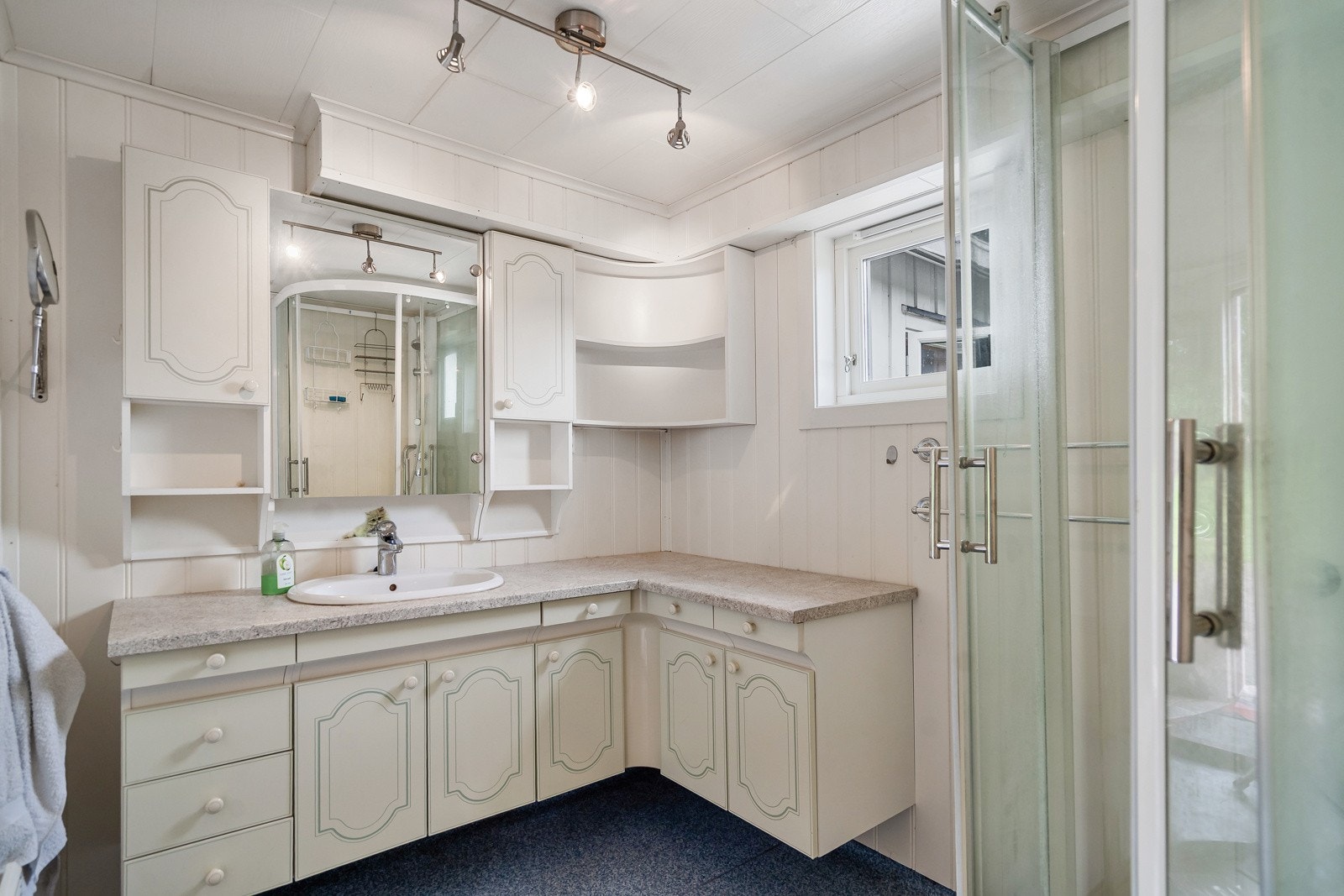 Badet har servantinnredning og dusjkabinett Galleribilde