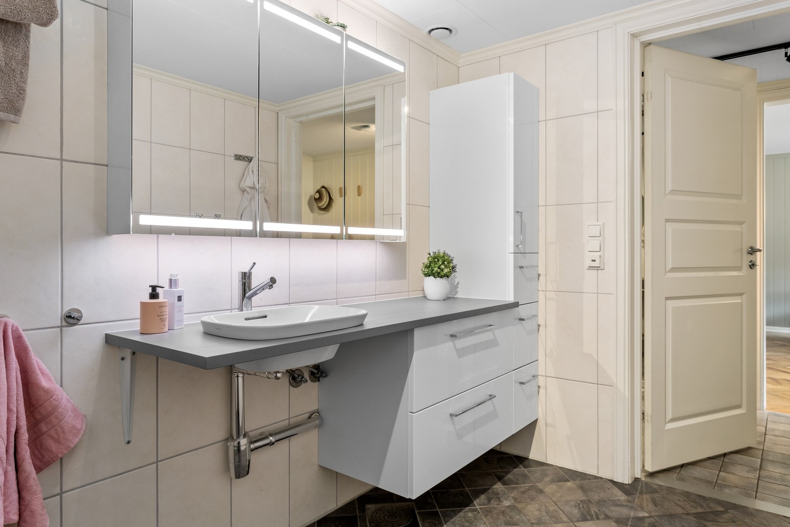 Badet har flislagt gulv med gulvvarme. Galleribilde