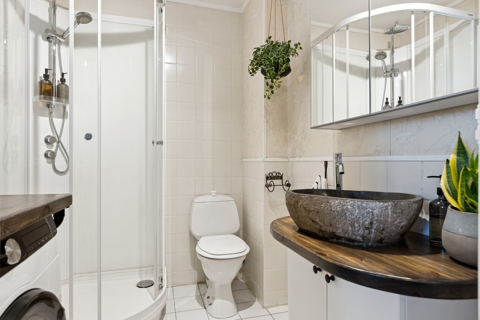 Badet er utstyrt med servantinnredning, speilskap, dusjkabinett og toalett, samt opplegg for vaskemaskin. Galleribilde