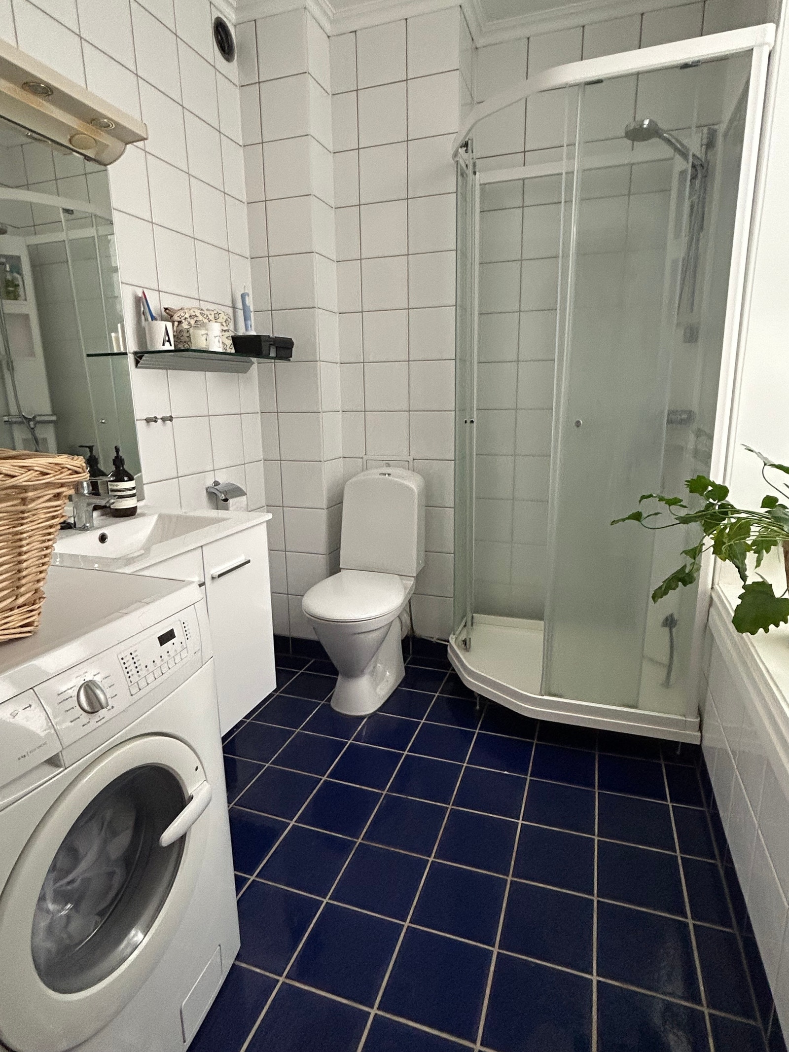 romslig flislagt baderom med varmekabler og vaskemaskin installert Galleribilde