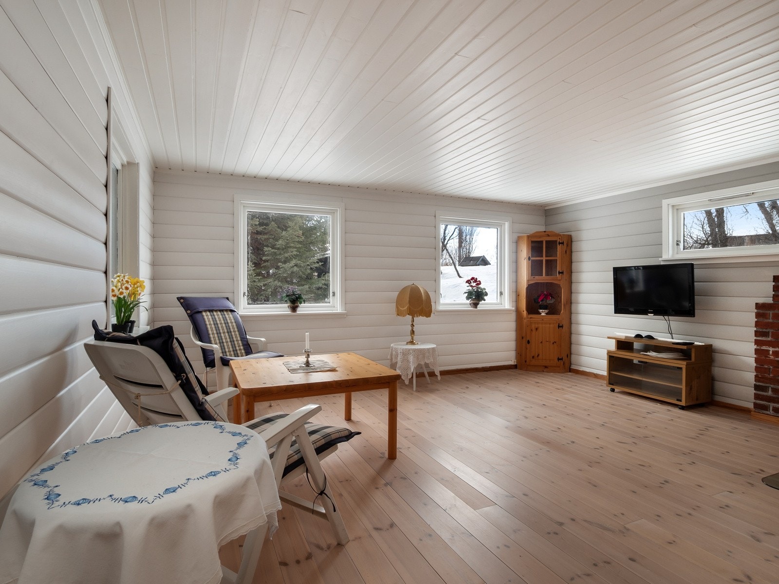 Stuen er holdt i lyse farger med mørkere detaljer, og store vindusflater sørger for naturlig lysinnslipp og fin utsikt Galleribilde