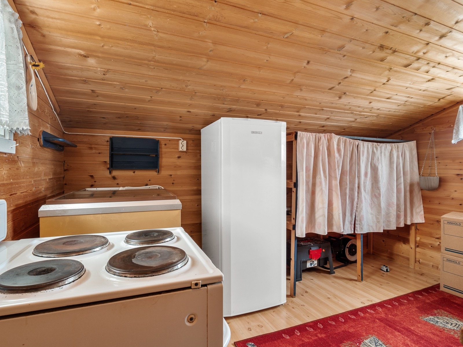 Fra kjøkkenkroken kan man gå inn i et tilbygg med eldre kjøkkeninnredning og opplegg for komfyr Galleribilde