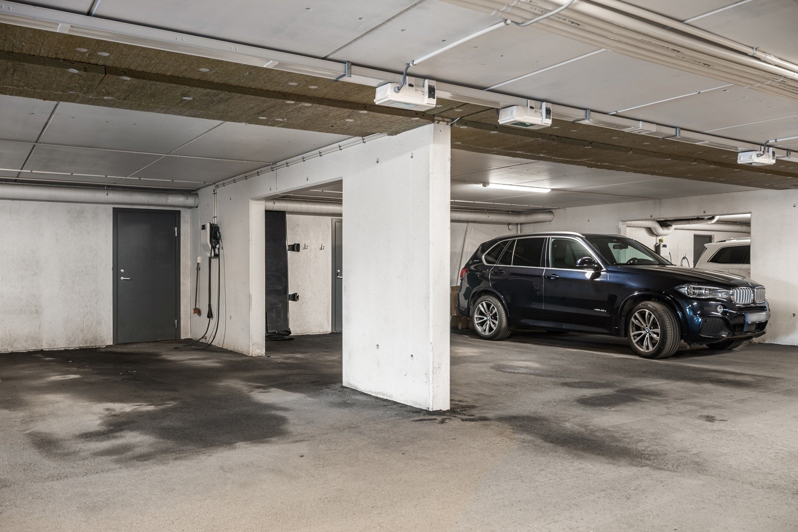 2 plasser i felles garasjekjeller - EL-billader medfølger - Direkte adkomst til boligens underetasje - Gå tørrskodd til bilen - Bildet ble tatt rett etter garasjevask Galleribilde