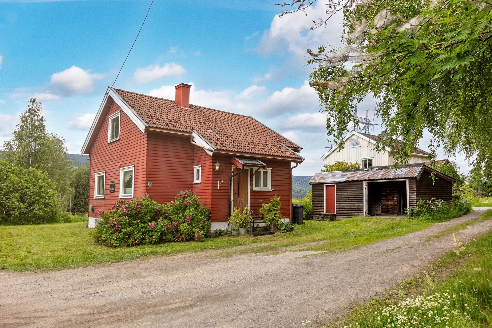Gruset innkjørsel, romslig gårdsplass med plenarealer. Galleribilde