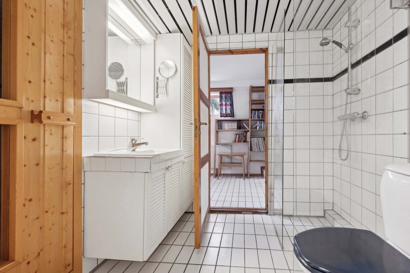 Bad i underetasjen har flislagt gulv med varmekabler og inneholder servant, toalett og dusjvegger/hjørne. Galleribilde