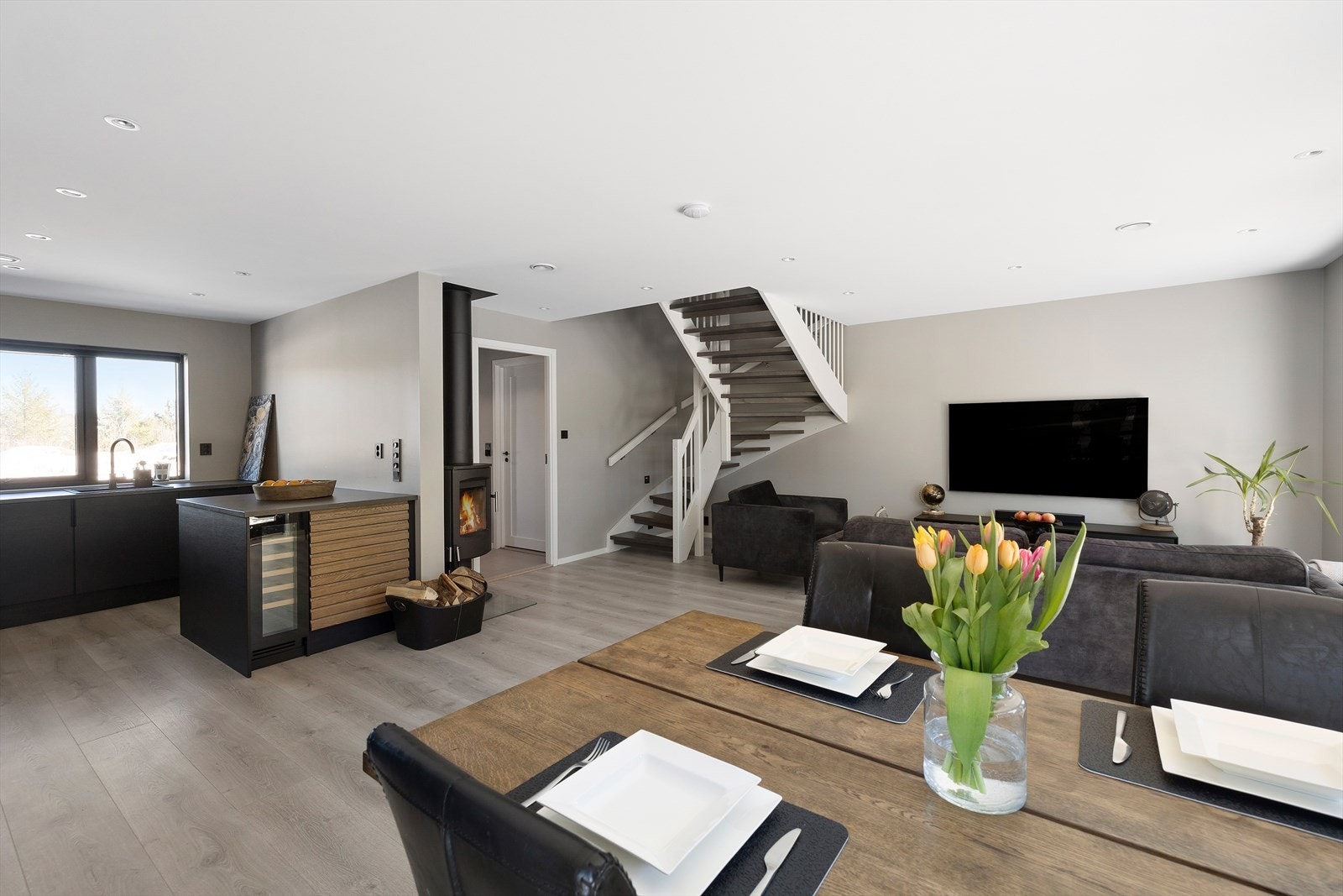 Pene malte flater og slitesterkt laminatgulv. Åpen kjøkkenløsning med et påkostet kjøkken. Galleribilde