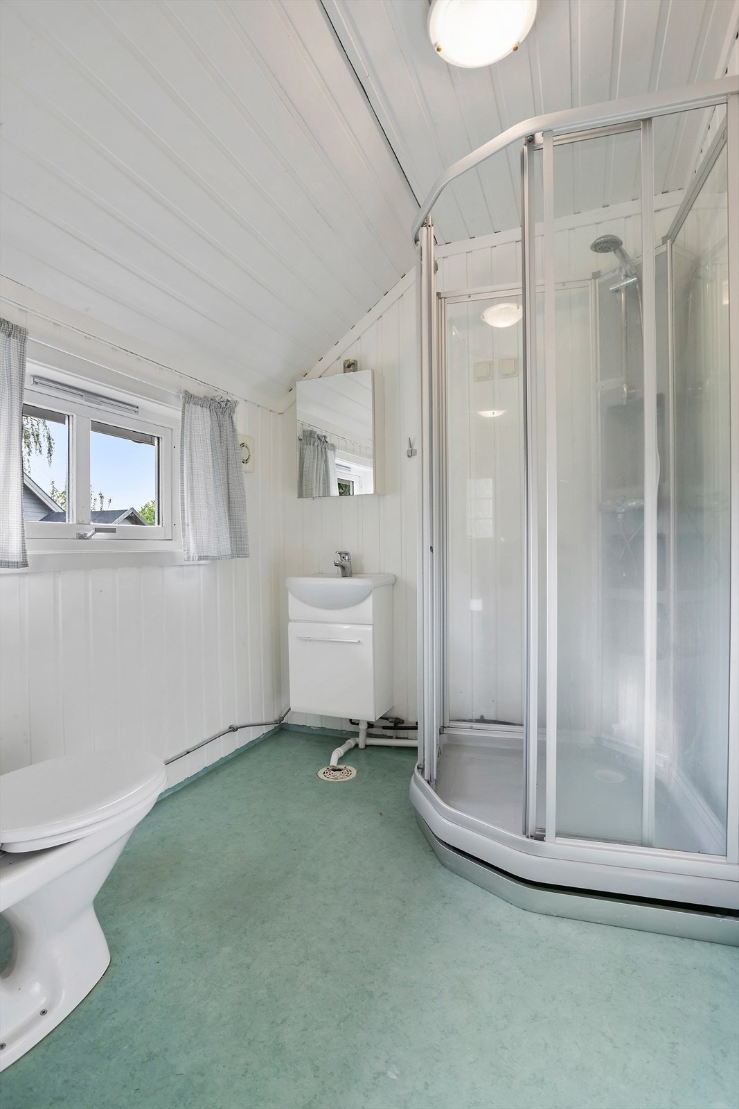 Bad i 1. etasje fra 1997 med gulv med belegg og vegger med malt panel Galleribilde